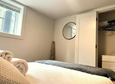 a bedroom with a bed and a mirror at Cedar & Sage Suite the Cozy Retreat with Full Kitchen in Victoria