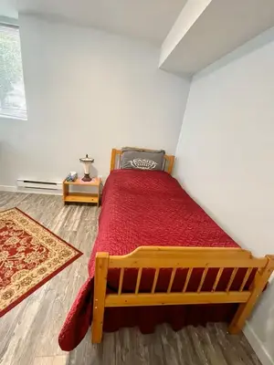 a bedroom with a wooden bed with a red blanket at Holiday Home in Coquitlam