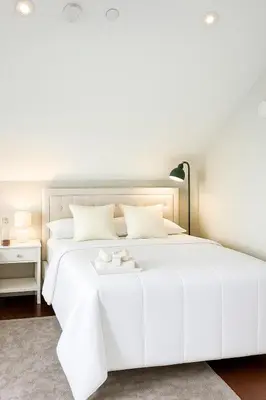 a white bedroom with a white bed and a table at The Cozy Quad In the Heart of Vancouver in Vancouver