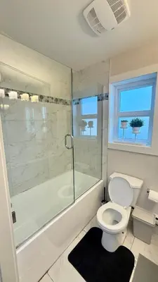 a bathroom with a shower and a toilet and a tub at The Cozy Quad In the Heart of Vancouver in Vancouver