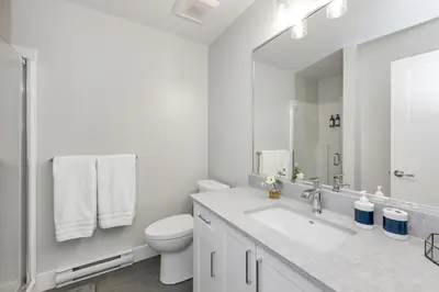 a white bathroom with a sink and a toilet at Cozy Langford suite in Langford