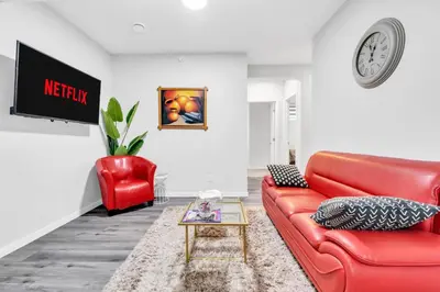 a living room with a red couch and a chair at Private, Stylish and Peaceful 2BR Guest Suite in Calgary