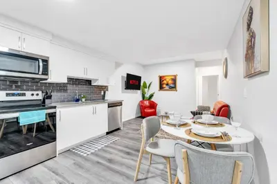a kitchen and dining room with a table and chairs at Private, Stylish and Peaceful 2BR Guest Suite in Calgary