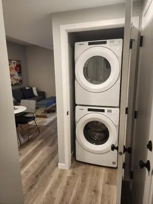 a washer and dryer in a living room at Brand New Modern 2 Bedroom Basement Suite in Calgary