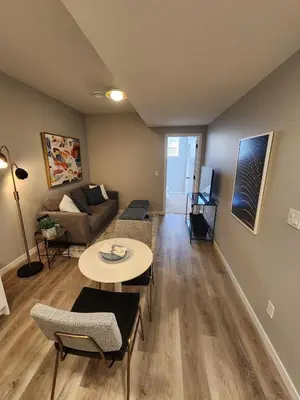 a living room with a couch and a table at Brand New Modern 2 Bedroom Basement Suite in Calgary