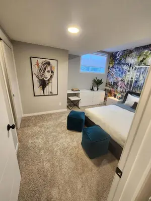 a bedroom with a bed and blue stools in it at Brand New Modern 2 Bedroom Basement Suite in Calgary
