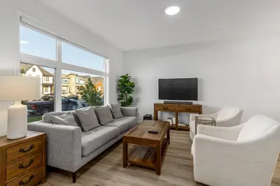 a living room with a couch and two chairs and a tv at King Bed, AC, Fenced Yard, Family Friendly, 5 min South Health Campus in Calgary