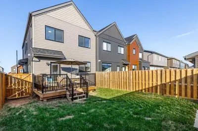 a backyard with a wooden fence and a house at King Bed, AC, Fenced Yard, Family Friendly, 5 min South Health Campus in Calgary