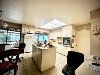 a kitchen with white appliances and a table and chairs at Cozy and spacious room near UBC-2 in Vancouver