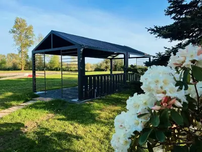 a black gazebo in a park with white flowers at Sunshine garden 3 bedrooms2 bathrooms1 living room1 kitchen in Aldergrove