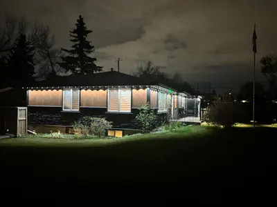 a house lit up at night with lights on it at Luxurious Air Conditioned Inner City Bungalow in Calgary