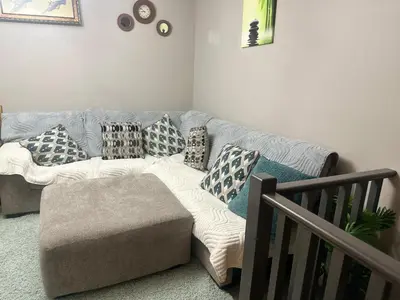 a couch in a living room with pillows on it at Spacious Bedroom-Near Airport YYC in Airdrie