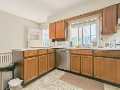 a kitchen with wooden cabinets and white appliances at Cozy Airb&b Suite in South Vancouver in Vancouver