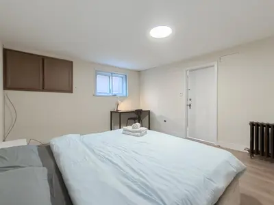 a white bedroom with a large bed in it at Cozy Airb&b Suite in South Vancouver in Vancouver