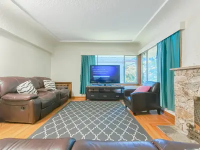 a living room with a couch and a television at Cozy Airb&b Suite in South Vancouver in Vancouver