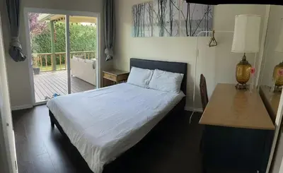 a bedroom with a bed and a table and a window at Vancouver Richmond Villa39 in Richmond