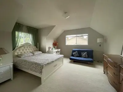 a bedroom with a bed and a blue chair at Vancouver Richmond Villa39 in Richmond