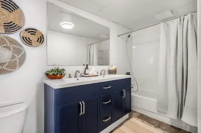 a bathroom with a sink and a toilet and a mirror at The Red Steps Away From World's Largest Dinosaur 3BR House in Drumheller