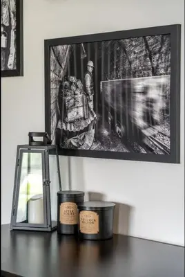 a table with three candles and a picture on the wall at The Coal Stone throw away from Red Deer River 2BR House in Drumheller
