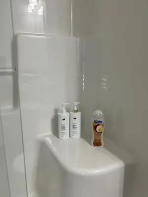a bathroom with two bottles ofodorizers sitting on a sink at 1-bedroom private suite, 20 minutes from the airport, with a kitchen in Edmonton