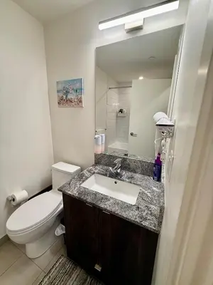 a bathroom with a sink and a toilet and a mirror at Victoria Colwood Place in Colwood