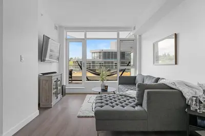a living room with a couch and a large window at Luxury Waterfront Suite with City Views and AC in Calgary