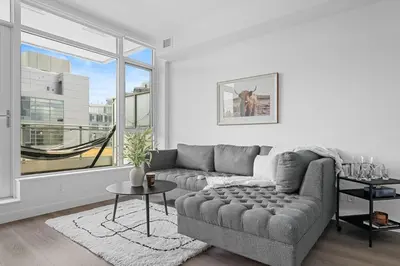a living room with a couch and a large window at Luxury Waterfront Suite with City Views and AC in Calgary