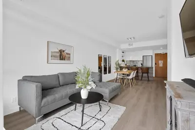 a living room with a couch and a table at Luxury Waterfront Suite with City Views and AC in Calgary