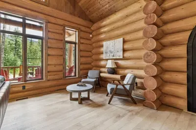 a living room with wooden walls and a table and chairs at Nordegg Timber Estate in Nordegg