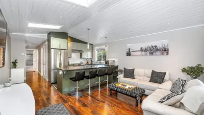 a living room with a couch and a kitchen at Knockan Hill Rentals - Garden Suite in Victoria