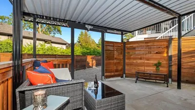 an outdoor patio with a white pergola at Knockan Hill Rentals - Garden Suite in Victoria
