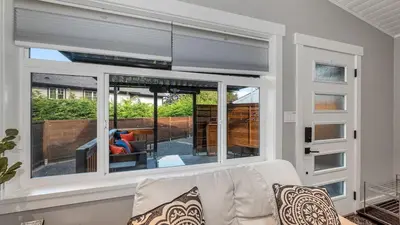a living room with a couch and a large window at Knockan Hill Rentals - Garden Suite in Victoria