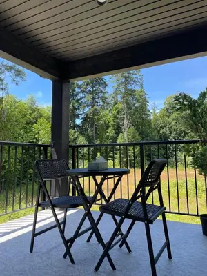 a table and two chairs sitting on a porch at Castle BNB 2025 in Gibsons
