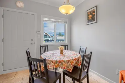 a dining room with a table and chairs and a window at Central Spacious 3 Br Upstairs in Vancouver