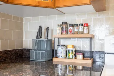 a kitchen counter with two wooden shelves with spices at Central Spacious 3 Br Upstairs in Vancouver