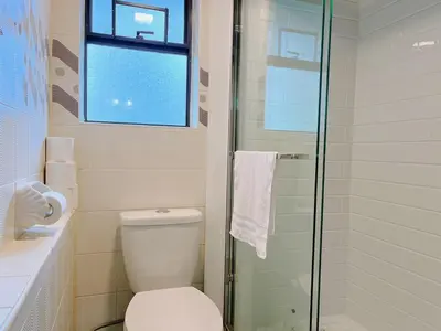 a bathroom with a toilet and a glass shower at Sunshine garden 5 bedrooms2 living rooms3 bathrooms1 kitchen in Aldergrove