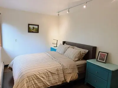 a bedroom with a bed and a blue night stand at Sunshine garden 5 bedrooms2 living rooms3 bathrooms1 kitchen in Aldergrove