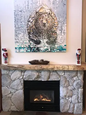 a painting of a dog is above a fireplace at XL Luxury Penthouse Ski-in Ski-out The Aspens in Whistler
