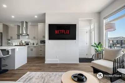 a kitchen and living room with a reactix sign on the wall at Executive Single Detached House with AC King Bed and More in Calgary