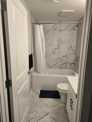 a bathroom with a tub and a toilet and a sink at Guest Suite in Southwest Calgary in Calgary
