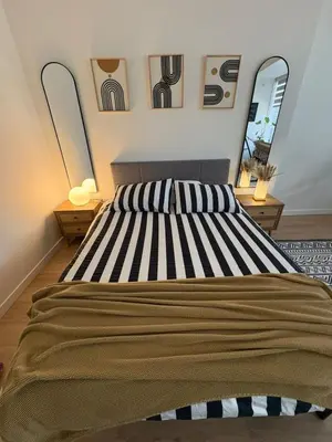 a bedroom with a large bed with two mirrors at Boho Studio Downtown Rogers Views Heated Parking in Edmonton