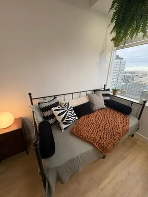 a bed with pillows on it in a room with a window at Boho Studio Downtown Rogers Views Heated Parking in Edmonton