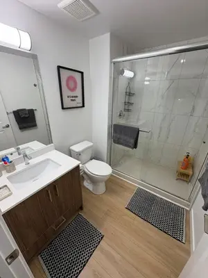 a bathroom with a shower and a sink and a toilet at Boho Studio Downtown Rogers Views Heated Parking in Edmonton