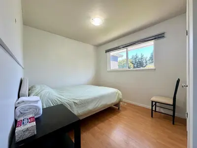 a bedroom with a bed and a desk and a window at Cozy 3 Bedrooms with Kitchen and Laundry Near Airport in Richmond