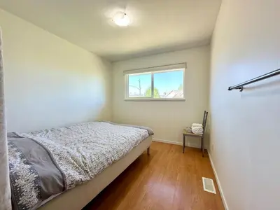a small bedroom with a bed and a window at Cozy 3 Bedrooms with Kitchen and Laundry Near Airport in Richmond