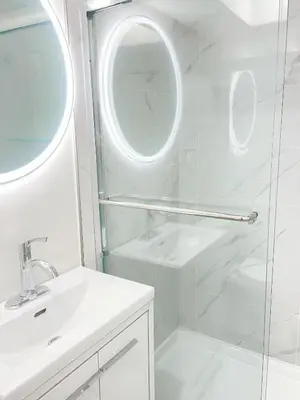 a bathroom with a shower and a sink and a mirror at Cozy New Suite 8mins to Downtown in Vancouver