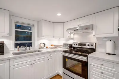 a kitchen with white cabinets and a stove top oven at Prestigious 2 Bedrooms 2 Baths in West Point Grey in Vancouver