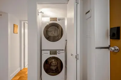 a washer and dryer in a room with a door at Prestigious 2 Bedrooms 2 Baths in West Point Grey in Vancouver