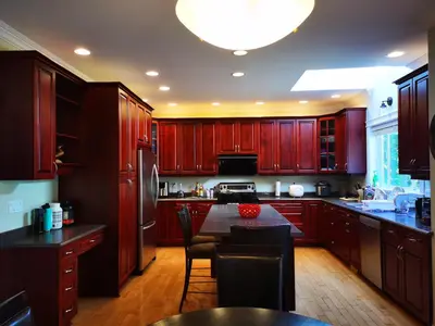 a kitchen with wooden cabinets and a table with chairs at Eagle's House, Room #B in Victoria