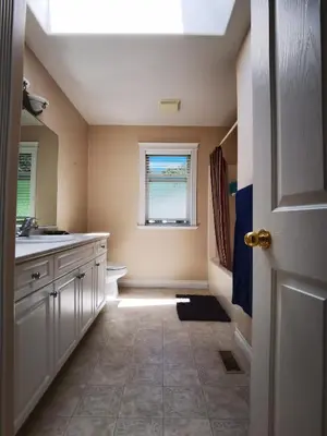 a bathroom with a sink and a toilet and a window at Eagle's House, Room #2 in Victoria